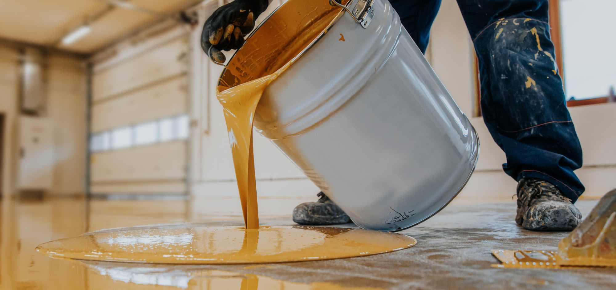 man pouring yellow epoxy