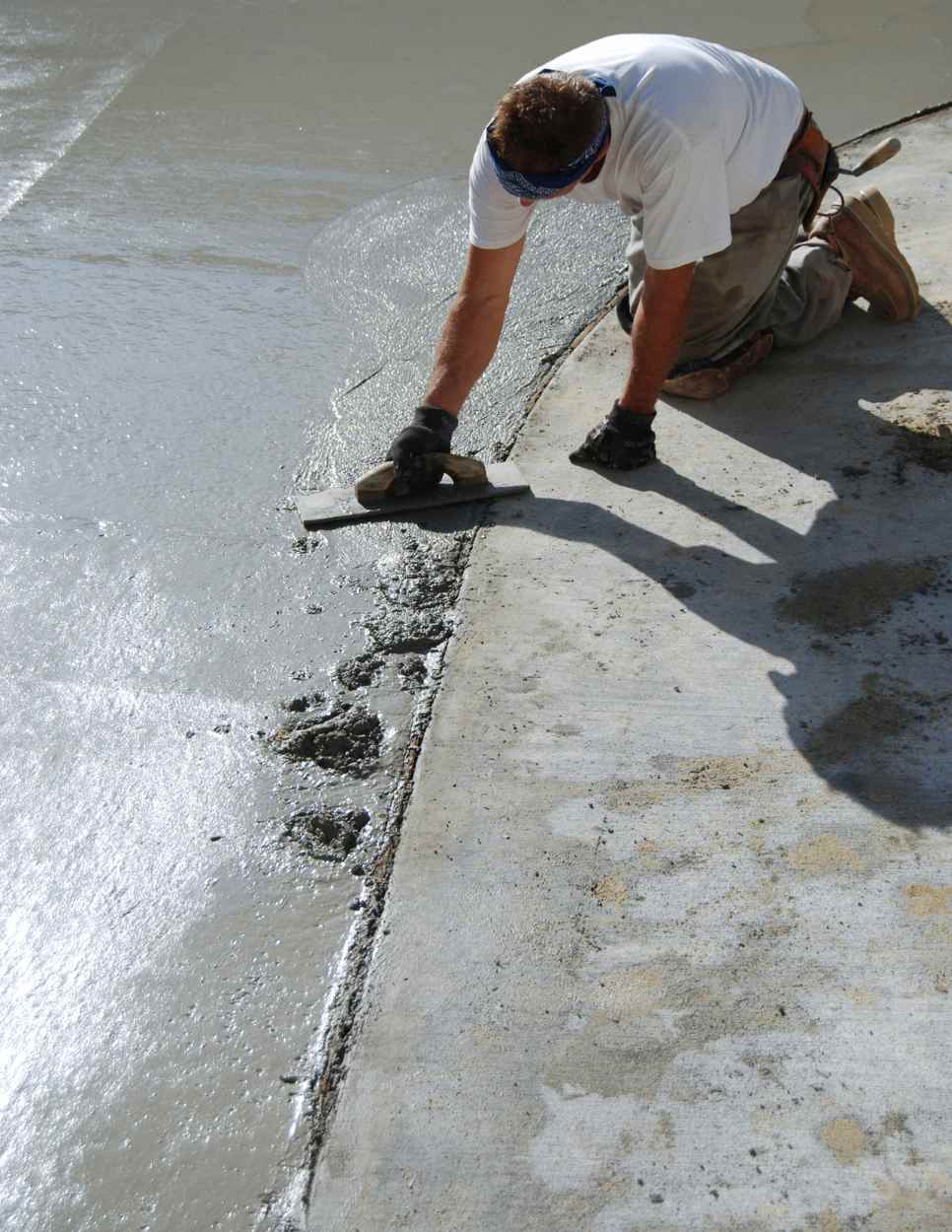 man smoothing concrete driveway